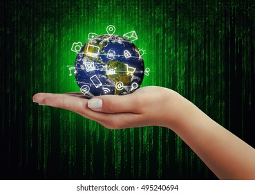 hand holding globe and media icons flying in front of matrix binary code background