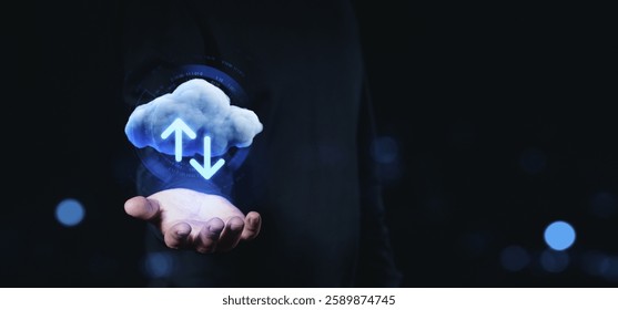 Hand holding a glowing cloud with up and down arrows, symbolizing cloud storage and data transfer on a dark background. Concept of online data exchange