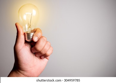 Hand holding a glowing light bulb - Shutterstock ID 304959785
