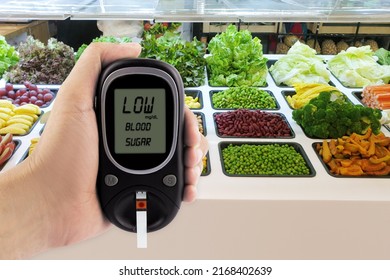 Hand holding glucose meter with blur of salad fresh fruits background, concept for slimming, healthy nutrition and strengthening immunity. - Shutterstock ID 2168402639