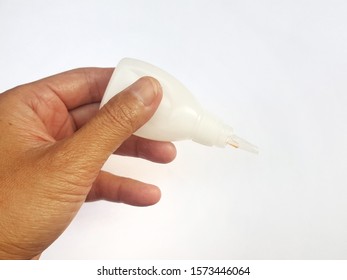 Hand Holding A Glue Bottle On A White Background.