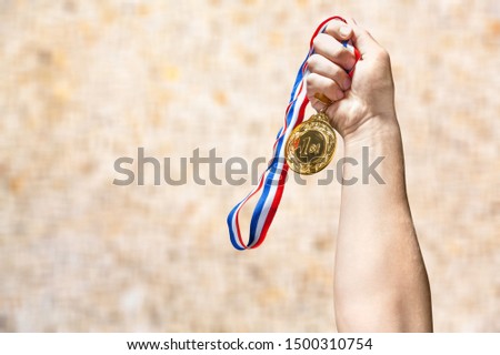 Hand holding gold medal on sky background, The winner and successful concept