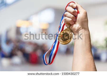 Hand holding gold medal on sky background, The winner and successful concept