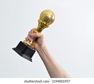 Hand Holding Golden Basketball Trophy On White Background.