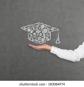 A Hand Holding A Graduation Hat