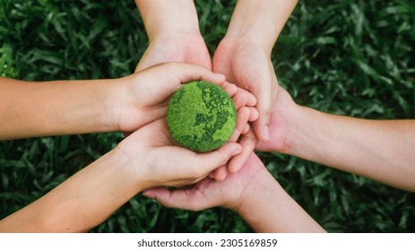 in hand holding green globe on green background Environmental concept, Earth Day and environmental protection. and environmental sustainability, helping the planet