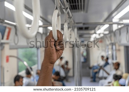 A hand holding a handle on Metrorail in Dhaka Bangladesh. The Dhaka Metro Rail is a mass rapid transit system serving Dhaka, the capital city of Bangladesh.
