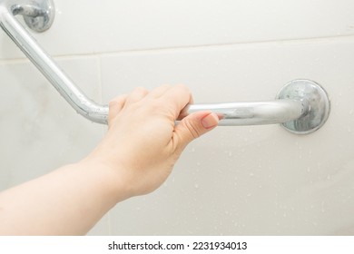 hand holding the handrail in the shower, safe bathing for the elderly and people with limited mobility