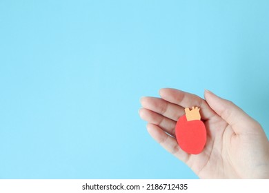 Hand Holding Heart Shape Made From Paper On Blue Background With