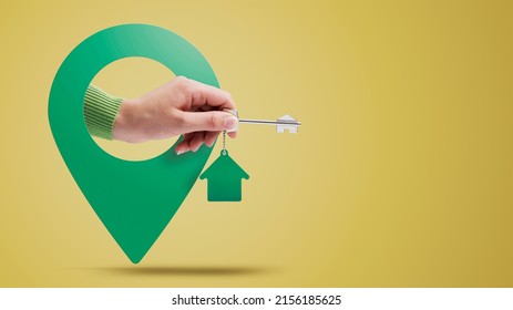 Hand Holding House Keys And Location Pin, Real Estate Concept