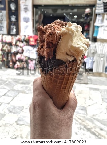 hand holding ice cream in a waffle cone