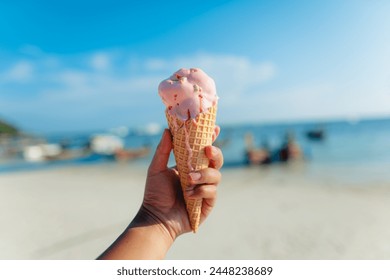 hand holding ice cream,Ice cream cone at the beach in summer - Powered by Shutterstock