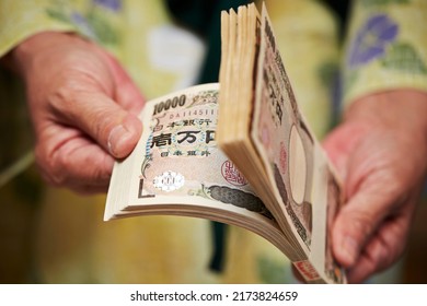 A hand holding Japanese money, one million yen	