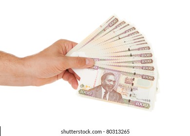 Hand Holding Kenyan Currency Over White Background