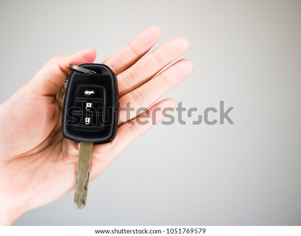 Hand\
holding key car on white background,copy\
space.