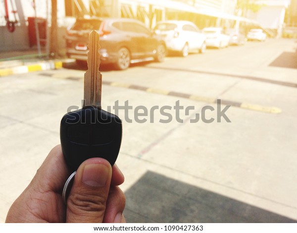 Hand holding key of car for start car, Key car\
on background
