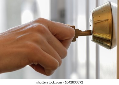 Hand Holding Key In Dead Bolt Lock