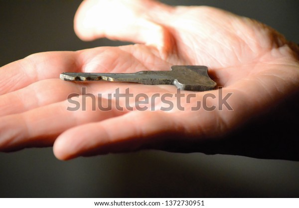Hand Holding Key in Open\
Hand