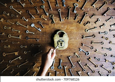 Hand Holding A Key To Unlock A Lock