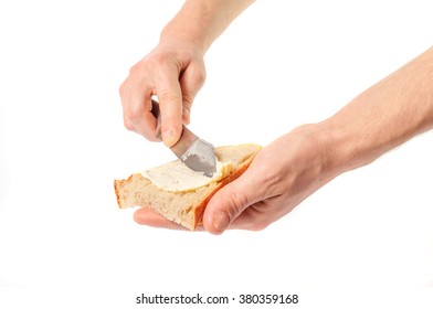 Hand holding knife spreading butter on bread. - Powered by Shutterstock