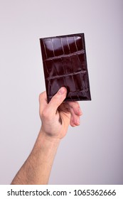 A Hand Holding A Leather Passport Holder