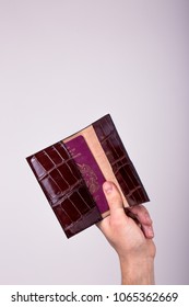 A Hand Holding A Leather Passport Holder