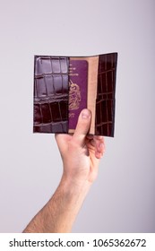 A Hand Holding A Leather Passport Holder