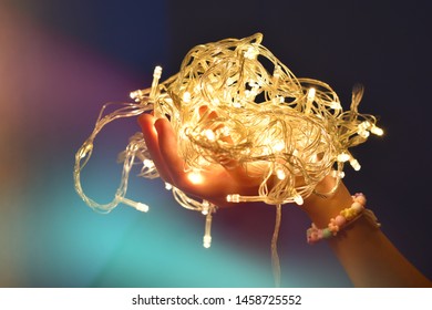 Hand Holding LED String Light That Are Used To Decorate The Festival