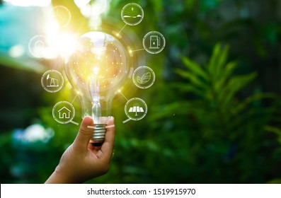 hand holding light bulb against nature, icons energy sources for renewable - Shutterstock ID 1519915970