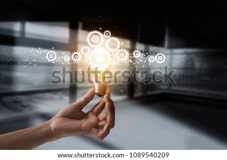 Hand holding light bulb and cog inside. Idea and imagination. Creative and inspiration. Innovation gears icon with network connection on metal texture background. Innovative technology in science  