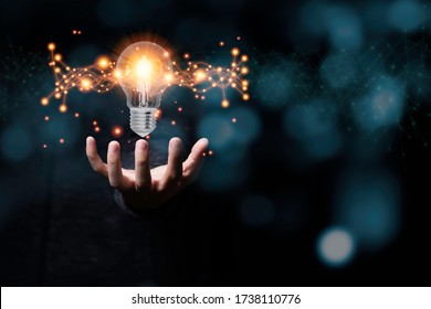 Hand holding light bulb glowing with orange light line and ray. Creative and new business idea concept. - Powered by Shutterstock