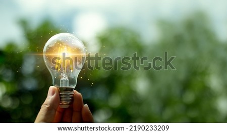 Hand holding a light bulb with light growing for renewable energy. creative ideas for save environment and sustainable. Eco energy concept. For web banner or web design.