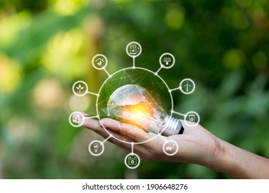 Hand holding light bulb with icons energy sources for renewable,love the world concept.