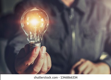  hand holding light bulb. idea concept with innovation and inspiration - Shutterstock ID 1346866334