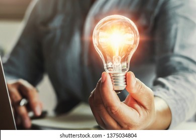 hand holding light bulb. idea concept with innovation and inspiration - Shutterstock ID 1375034804