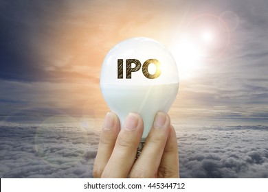 hand holding light bulb with IPO text on sky background , business analysis and strategy as concept