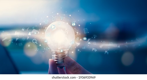 Hand holding light bulb with media icon on digital innovation and creativity are keys to success. Concept knowledge leads to ideas and inspiration. - Shutterstock ID 1936933969