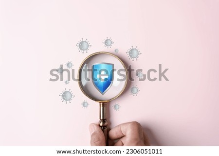 Hand holding magnifier focus to protection shield anti virus and bacteria, Health care secure concept.