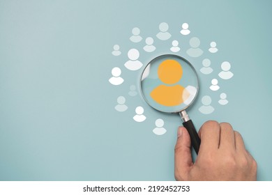 Hand Holding Magnifier Glass With Yellow Person Icon Among White People Icons For Customer Focus Group ,recruitment And Human Development Concept.