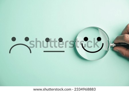 Hand holding magnifier happy smiley face icon among emotions. Good feedback rating, positive customer review, and satisfaction survey., mental health concept. Certificate signifies satisfaction.