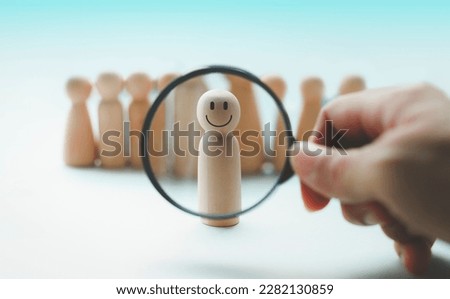 Hand holding a magnifying glass emotion face icon, in human resource search, talent management.