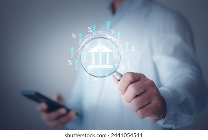 Hand holding magnifying glass focus a debt rate with an increase percent icon, debt increase, interest burden, interest rate rise, federal reserve or central bank raising policy, monetary percentage. - Powered by Shutterstock