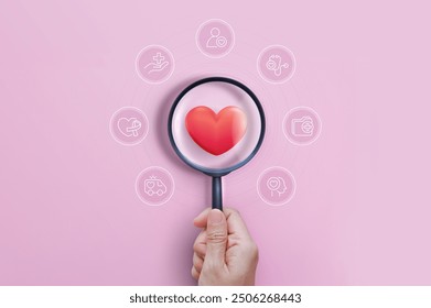 Hand holding magnifying glass focus heartbeat on pink background for checking the function of the patient heart. health insurance, love, international cardiology day, check up, cardiology. - Powered by Shutterstock