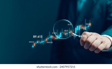 hand holding a magnifying glass with graph stock market. Business finance investment fun forex and exchange chart economic money  - Powered by Shutterstock