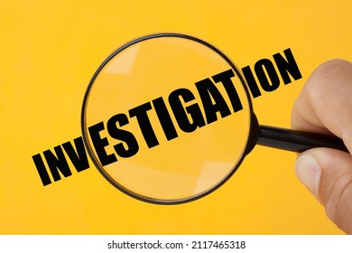Hand holding magnifying glass over the word Investigation.
