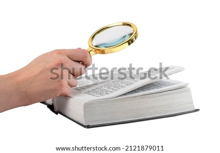 Hand holding magnifying glass for reading book isolated on white background. Relevant information search, study concept. High quality photo