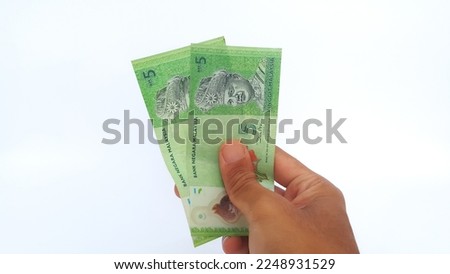 Hand holding Malaysian Ringgit money on white background. Five Malaysian ringgit banknotes.