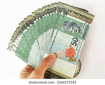 Hand holding a Malaysian Ringgit (RM 50) banknote on isolated white background 