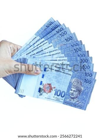 Hand holding Malaysian Ringgit (RM 100) banknote on isolated white background 