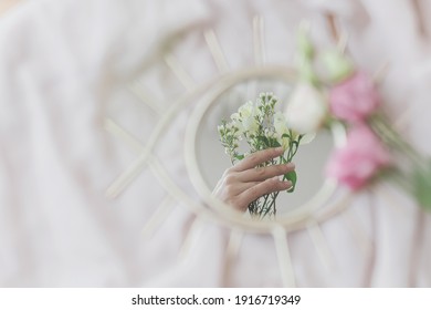 Hand Holding Manuka Flowers Reflected In Mirror On Background Of Soft Fabric. Spring Aesthetics. Happy Womens And Mothers Day. Mental Health Concept. Gentle Image. Eye Shape Boho Mirror